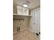 This laundry room includes overhead shelving, tile floors, and washer/dryer hookups at 11055 Belle Haven Dr, New Port Richey, FL 34654