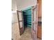 An open pantry with turquoise painted walls and sturdy metal shelving offers ample storage in this home at 11055 Belle Haven Dr, New Port Richey, FL 34654