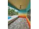 Covered patio with colorful walls, pavers, and views of the pool and landscaped backyard at 11055 Belle Haven Dr, New Port Richey, FL 34654