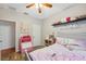 Bright bedroom with a ceiling fan, wood floors, playful wall art, and cozy furniture at 1108 Blackwater Dr, Wesley Chapel, FL 33543