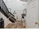 Welcoming foyer with wood-look tile flooring, black and brown staircase, and decorative wall hangings at 1108 Blackwater Dr, Wesley Chapel, FL 33543