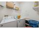 Functional laundry room equipped with a washer, dryer, storage shelves, and laundry supplies at 1108 Blackwater Dr, Wesley Chapel, FL 33543
