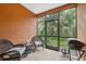Enclosed patio with wicker furniture, ceiling, grill, and a view of the green yard at 1108 Blackwater Dr, Wesley Chapel, FL 33543