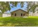 The rear exterior of the home showcases a well-manicured lawn and an enclosed porch at 11158 Heathrow Ave, Spring Hill, FL 34609