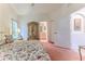 Bright primary bedroom with a large bed, floral accents, and an arched doorway at 11158 Heathrow Ave, Spring Hill, FL 34609
