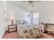Cozy bedroom featuring plush carpeting, a ceiling fan and a comfortable floral-patterned bed at 11158 Heathrow Ave, Spring Hill, FL 34609
