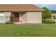 Charming home featuring a well-manicured lawn and inviting front entrance with a red door at 11158 Heathrow Ave, Spring Hill, FL 34609