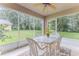 Screened lanai with ceiling fan, white table and chairs, offering a peaceful outdoor dining space at 11158 Heathrow Ave, Spring Hill, FL 34609