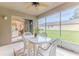 Cozy screened lanai with fan, dining table and chairs, leading to an open kitchen space at 11158 Heathrow Ave, Spring Hill, FL 34609