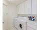 Neat laundry room featuring white cabinets and modern washer and dryer at 11158 Heathrow Ave, Spring Hill, FL 34609