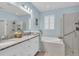 Elegant bathroom with double vanity, granite countertops, a soaking tub, and separate glass shower offers a spa-like experience at 11308 Mollymawk Ct, New Port Richey, FL 34654