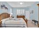 Bright and airy bedroom with traditional wooden furniture, soft blue walls, and shuttered windows for a serene space at 11308 Mollymawk Ct, New Port Richey, FL 34654
