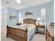 Traditional bedroom with light blue walls, a wooden bed frame, matching bedside tables, and windows with plantation shutters at 11308 Mollymawk Ct, New Port Richey, FL 34654