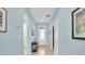 Bright hallway with light blue walls, tile flooring, and multiple doorways at 11308 Mollymawk Ct, New Port Richey, FL 34654