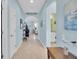 Long hallway with tile flooring, blue walls, and decorative artwork accents at 11308 Mollymawk Ct, New Port Richey, FL 34654