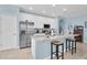 This kitchen features white cabinets, stainless steel appliances, granite countertops and an island with barstool seating at 11308 Mollymawk Ct, New Port Richey, FL 34654