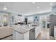Kitchen island with granite countertop, stainless steel dishwasher, and seating overlooking the living area at 11308 Mollymawk Ct, New Port Richey, FL 34654