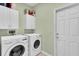 Well-equipped laundry room with washer, dryer and storage cabinets at 11308 Mollymawk Ct, New Port Richey, FL 34654
