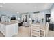 Open concept living space features kitchen island, dining table, and living room with sliding glass doors and bright, neutral decor at 11308 Mollymawk Ct, New Port Richey, FL 34654