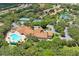 Aerial view of community amenities featuring a large pool, tennis courts, a clubhouse, and a scenic pond at 11389 Mcnally Dr, Spring Hill, FL 34609
