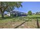 A screened-in lanai with a large grassy backyard and mature trees offers outdoor enjoyment at 11389 Mcnally Dr, Spring Hill, FL 34609