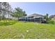 Large backyard with screened-in lanai, showcasing outdoor living and mature trees at 11389 Mcnally Dr, Spring Hill, FL 34609