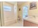 Bright bathroom featuring a shower and tub combo, tile floors, and light wood vanity with backyard access at 11389 Mcnally Dr, Spring Hill, FL 34609