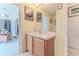 Bright bathroom featuring a door to the patio area, tile floors, and light wood vanity at 11389 Mcnally Dr, Spring Hill, FL 34609