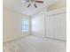Neutral bedroom featuring a ceiling fan, window, carpet, and a double door closet at 11389 Mcnally Dr, Spring Hill, FL 34609