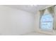 Bedroom with a large window with curtains. The room is carpeted and painted a neutral color at 11389 Mcnally Dr, Spring Hill, FL 34609