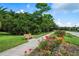 A serene view of the community sidewalk, complemented by a bench and vibrant red roses at 11389 Mcnally Dr, Spring Hill, FL 34609