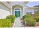 Inviting entrance with a double-door entryway framed by lush greenery and garden lighting at 11389 Mcnally Dr, Spring Hill, FL 34609
