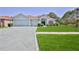 Inviting one-story home with a manicured front yard and a long, patterned driveway at 11389 Mcnally Dr, Spring Hill, FL 34609