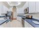 Bright kitchen with white cabinetry, stainless steel appliances, and tile floors at 11389 Mcnally Dr, Spring Hill, FL 34609