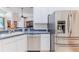 Open kitchen with stainless steel appliances, white cabinets, and a view of the living room at 11389 Mcnally Dr, Spring Hill, FL 34609