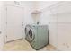 Bright laundry room featuring modern washer, dryer, shelving, and a convenient exterior access door at 11389 Mcnally Dr, Spring Hill, FL 34609