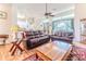 Comfortable living room features hardwood floors, ceiling fan, large window and plush, leather furniture at 11389 Mcnally Dr, Spring Hill, FL 34609