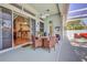 Covered patio with dining set, ceiling fan, and view into the kitchen through sliding glass doors at 11389 Mcnally Dr, Spring Hill, FL 34609
