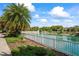Scenic pond with fountain, enhanced by lush landscaping and a white picket fence at 11389 Mcnally Dr, Spring Hill, FL 34609