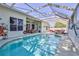 Enclosed pool area featuring clear water, ample seating, and a screened enclosure for relaxing outdoors at 11389 Mcnally Dr, Spring Hill, FL 34609