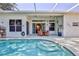 Enclosed pool featuring stairs, screened-in lanai, clear water, and an inviting outdoor space at 11389 Mcnally Dr, Spring Hill, FL 34609