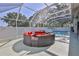 Enclosed pool featuring a circular seating arrangement, screened enclosure, and inviting outdoor space at 11389 Mcnally Dr, Spring Hill, FL 34609