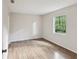 Bedroom featuring hardwood floors, neutral walls, and a window overlooking a wooded area at 11751 Key Lime Dr, New Port Richey, FL 34654