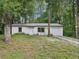 Charming single-story home with a well-maintained lawn and attached one car garage surrounded by trees at 11751 Key Lime Dr, New Port Richey, FL 34654