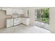 Well-lit kitchen with white appliances and cabinets, granite countertops, and sliding doors leading to the patio at 11751 Key Lime Dr, New Port Richey, FL 34654