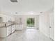 Bright kitchen featuring granite counters, modern appliances, tile flooring, and a view of the trees through sliding glass doors at 11751 Key Lime Dr, New Port Richey, FL 34654