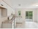 Cozy kitchen featuring granite countertops, modern appliances, and a view of the trees through sliding glass doors at 11751 Key Lime Dr, New Port Richey, FL 34654