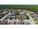 Expansive aerial view of a well-maintained residential community with lush landscaping, sidewalks and homes backing up to a wooded area at 12750 Tikal Way, Trinity, FL 34655