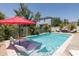Relaxing backyard pool area with lounge chairs, umbrellas, and a beautifully landscaped garden at 12750 Tikal Way, Trinity, FL 34655
