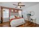 Cozy bedroom with a ceiling fan, accent wall, and a desk and vanity area at 12750 Tikal Way, Trinity, FL 34655